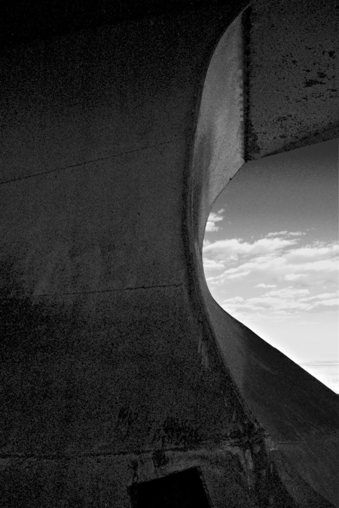 Abstract, railway snowplow against sky with scattered clouds