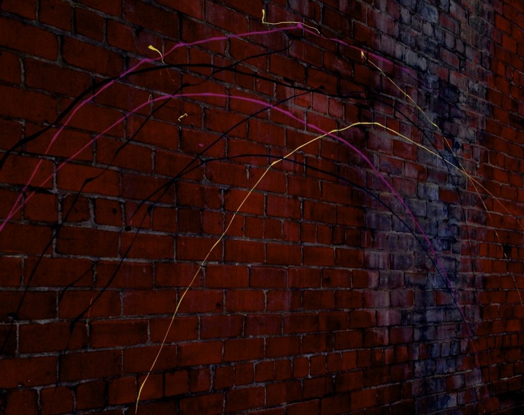 Paint streaks on red brick wall