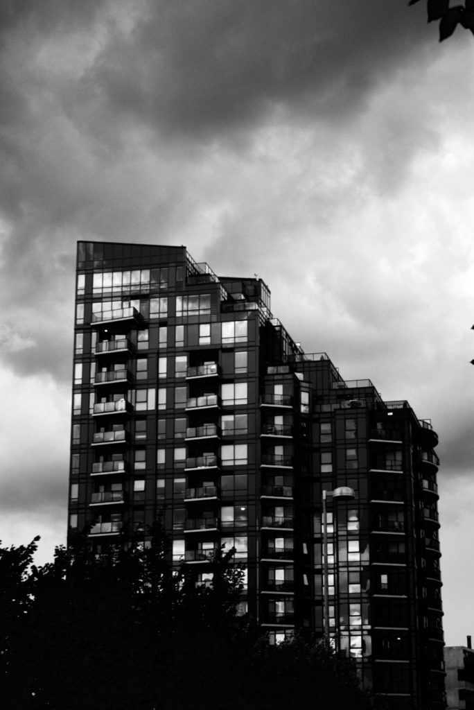 modern condo tower with storm clouds