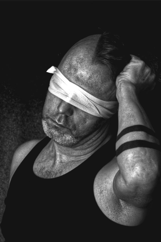 Portrait of blindfolded male with tattoos