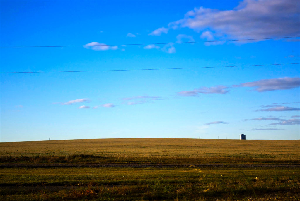 Landscape of grain silo silhouetted on hill top